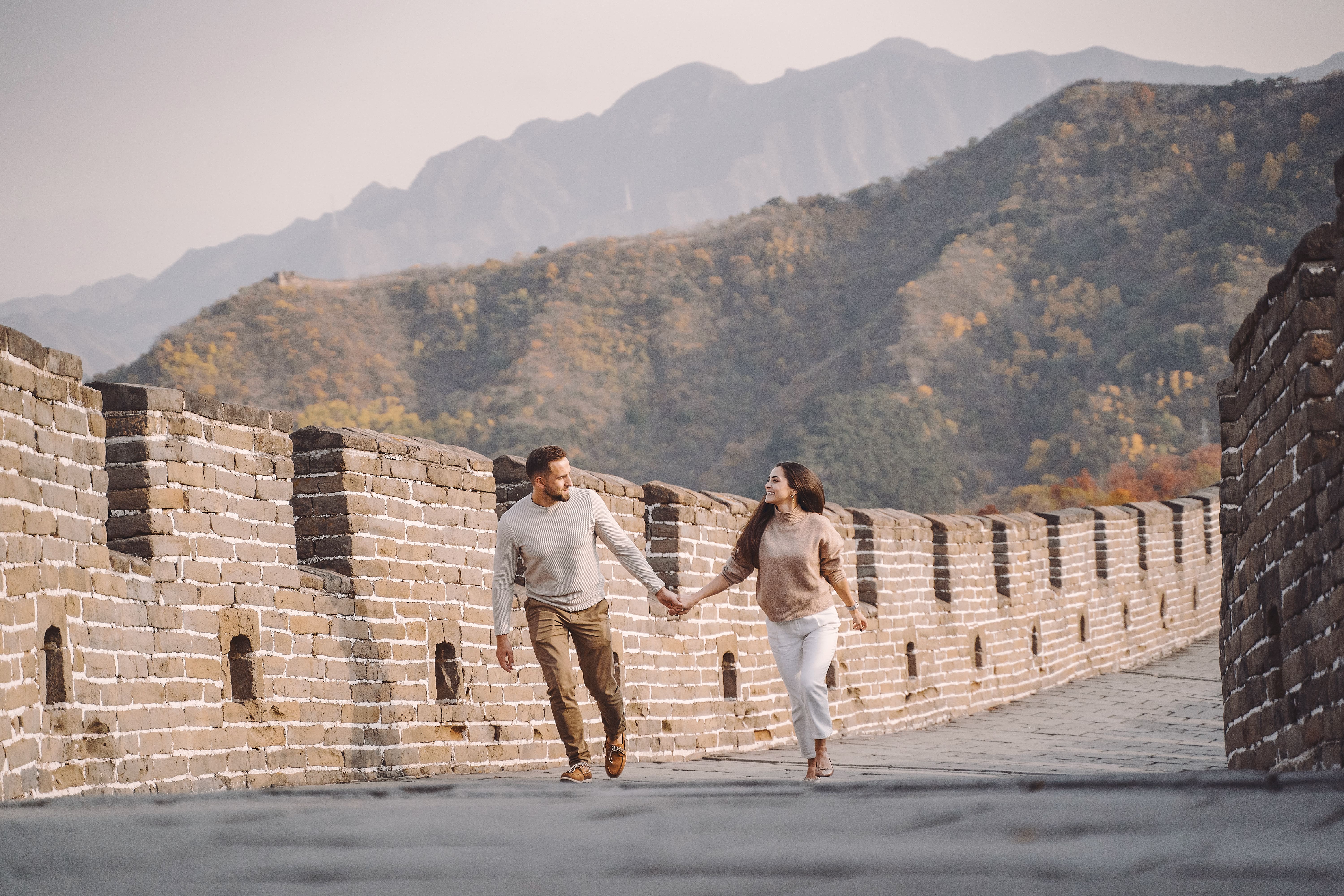 beau-jeune-couple-courir-et-sauter-a-la-grande-muraille-de-chine (1)