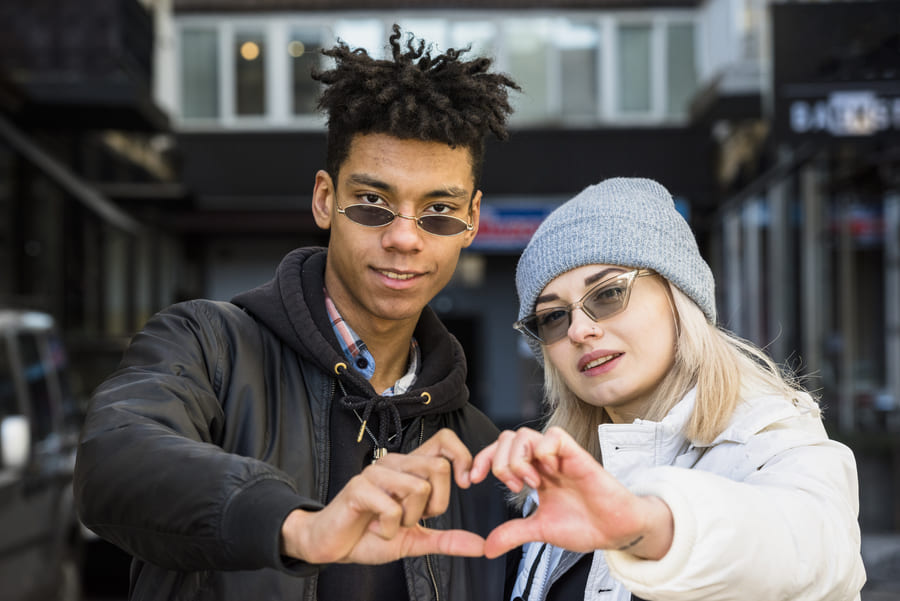 sourire portrait de couple interracial lunettes de soleil en forme de coeur avec leurs mains1